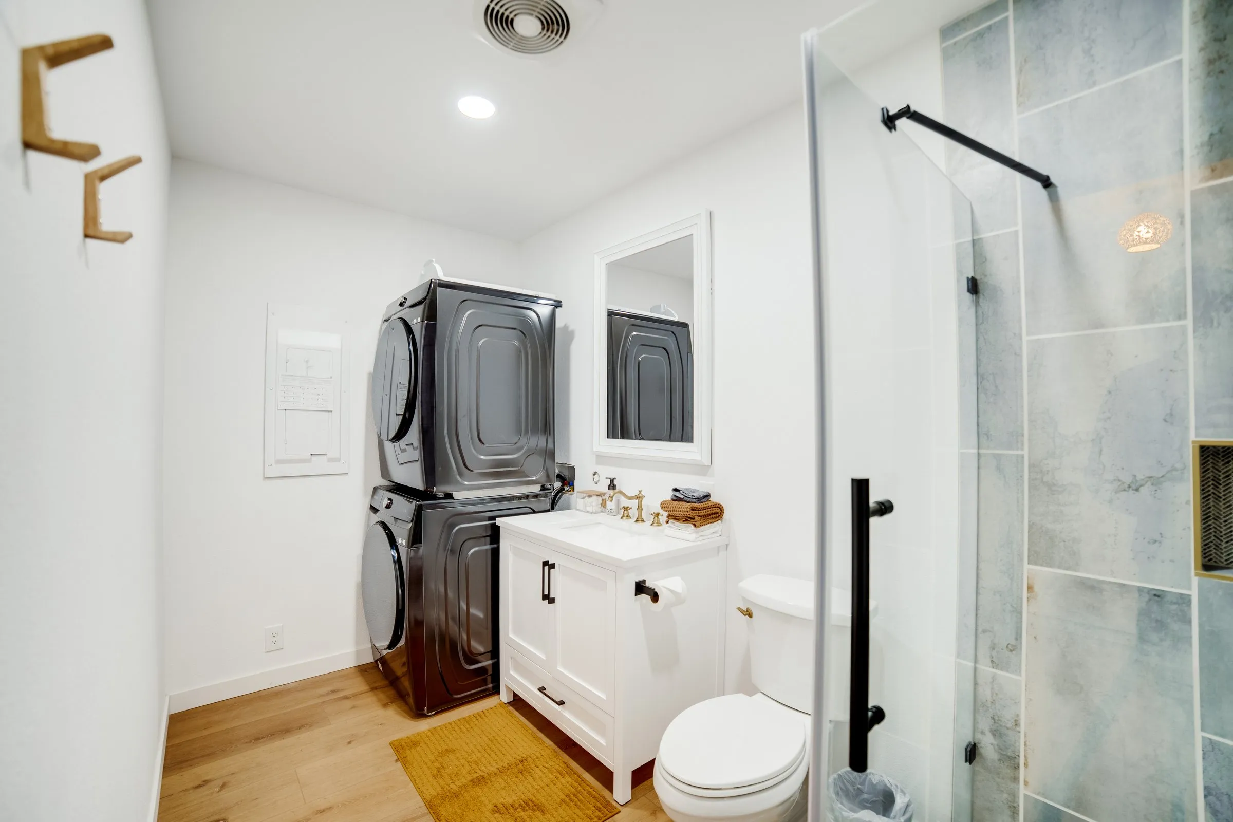 Bathroom with stacked washer and dryer and tiled shower