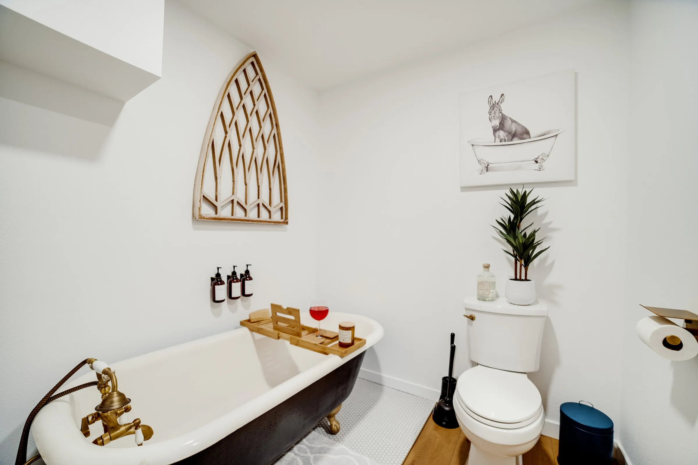 Spa-style bathroom with clawfoot tub and gothic arch wall art