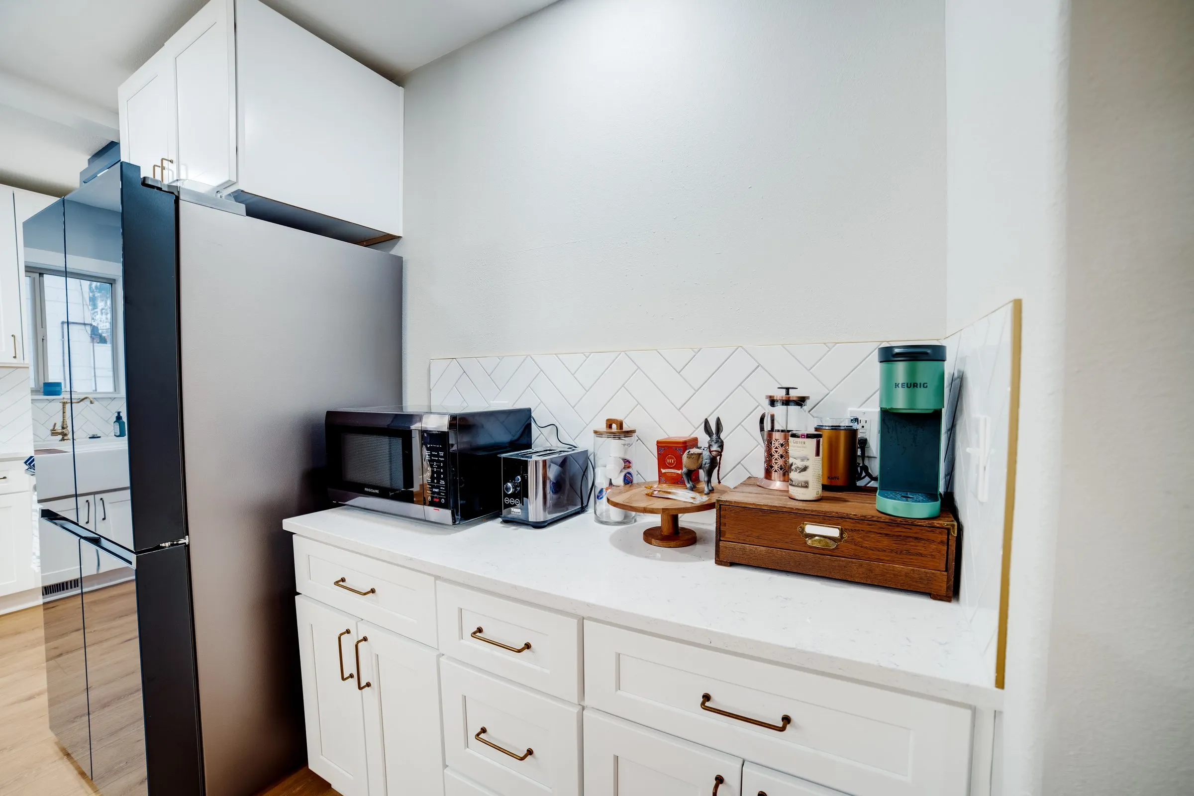 Coffee bar stocked with a Keurig, French press, microwave and toaster