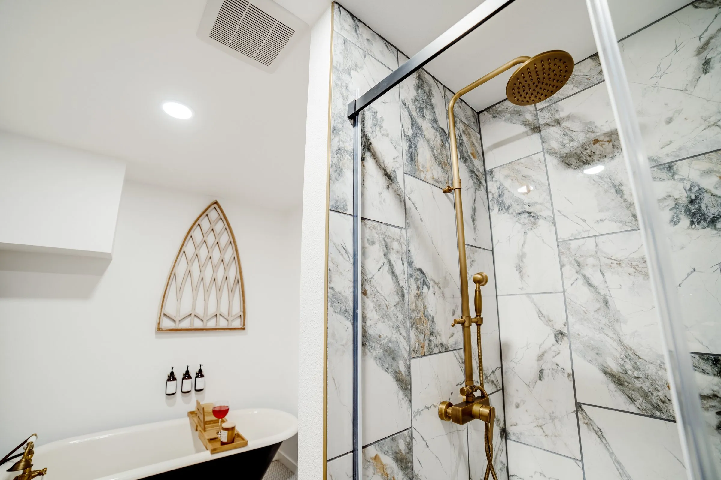 Marble-tiled shower with a brass rainfall showerhead